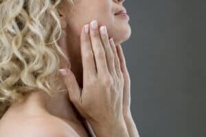 woman touching her jowls